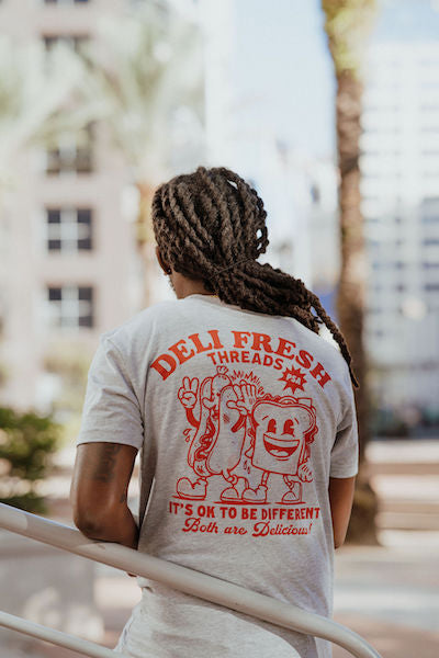 Guy showing off the Back of the Hot Dog and Sandwich high fiving - It's Ok to be Different both are delicious 