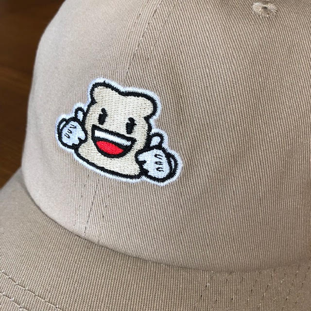 Close up of the Biggie Bread embroidered  on a khaki relaxed fit hat.