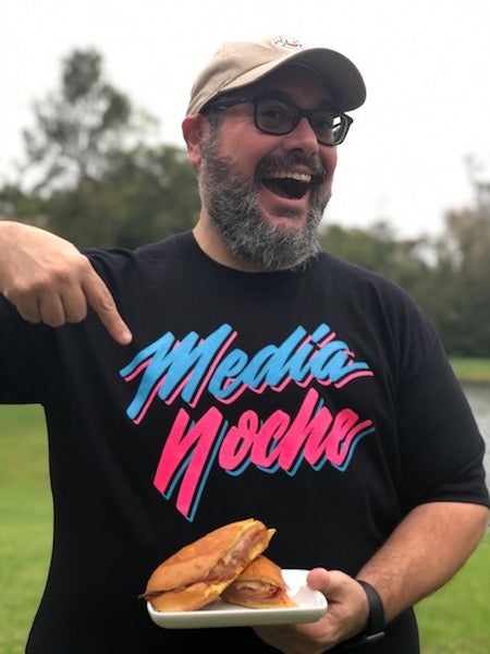 guy wearing a Miami Media Noche with a media noche sandwich