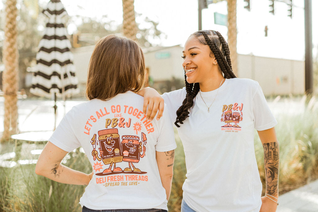Girls showing off the front and back of the Peanut Butter and Jelly- Spread the love t-shirt