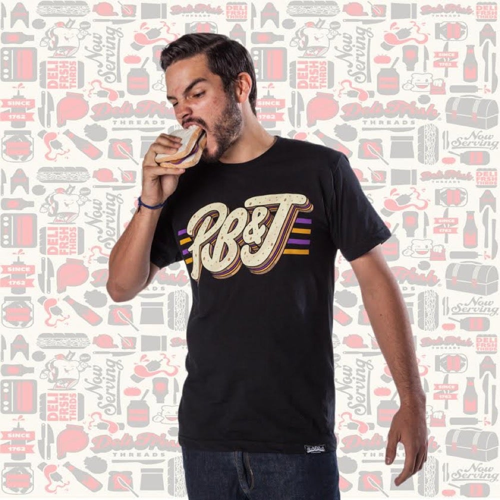 Guy wearing a Peanut Butter and Jelly T-shirt eating a PB&J sandwich